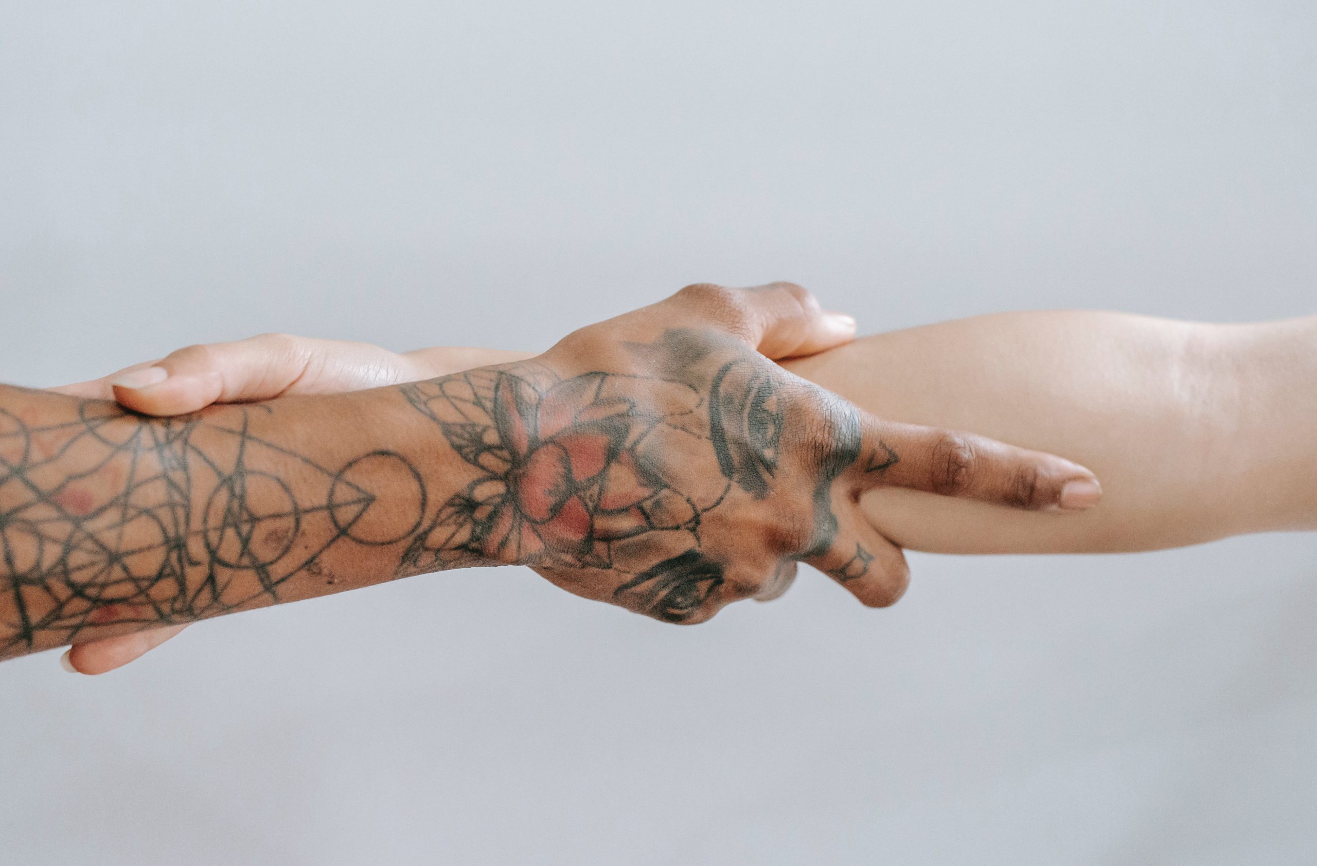 two people holding one another's forearms