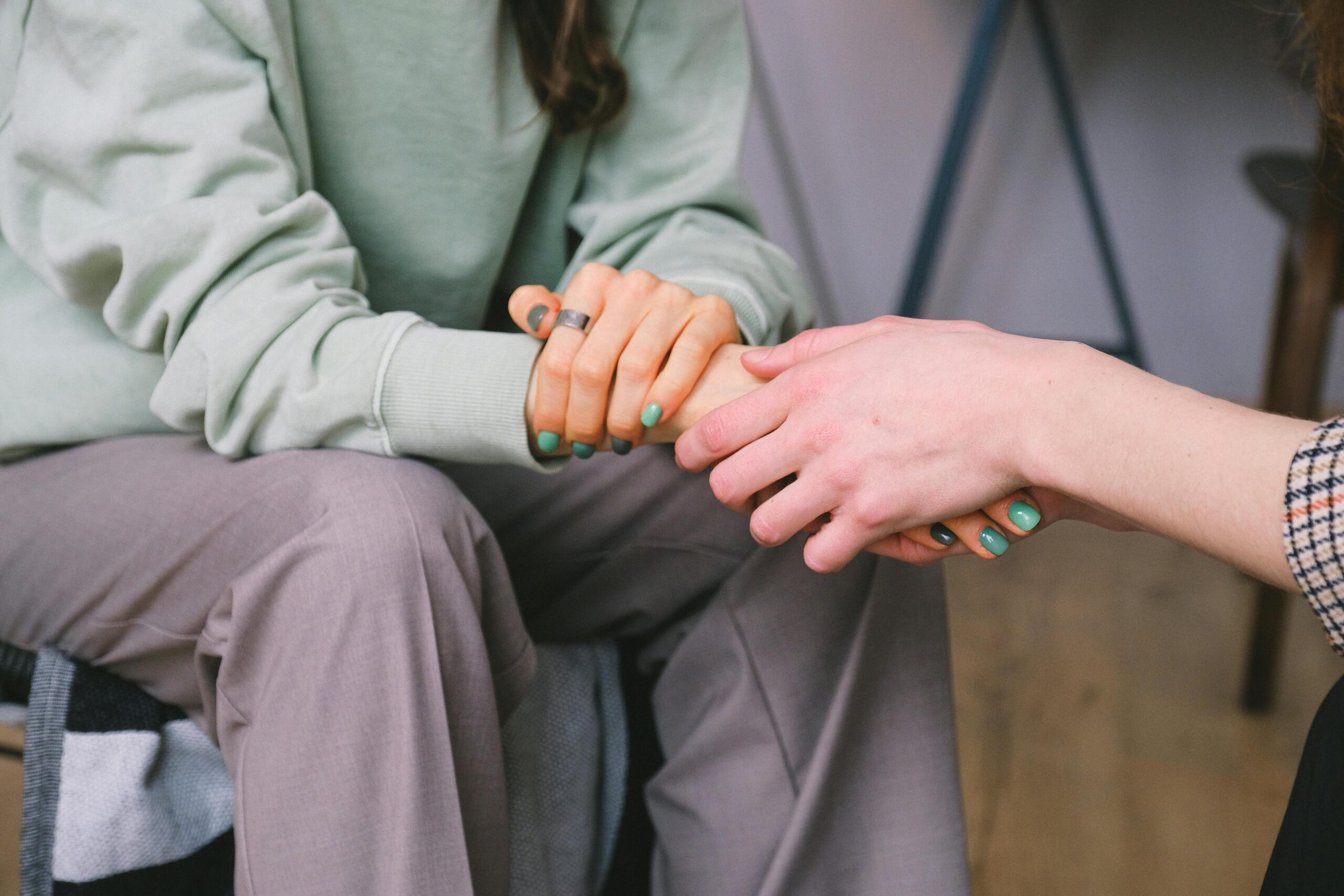 image shows two people holding hands for emotional support